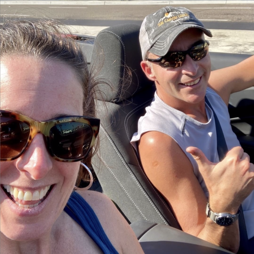 photo of Scott & Christine in a convertible with big grins other faces- so excited to be in sunshine and warm weather. 