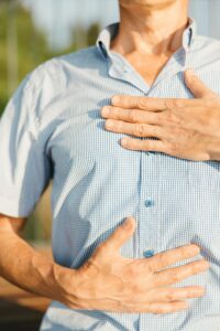 Person with hands on chest, tuning into physical sensations and emotions in the body